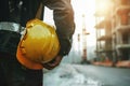 Worker engineer ensures construction safety, holding hard hat helmet Royalty Free Stock Photo