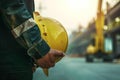 Worker engineer ensures construction safety, holding hard hat helmet Royalty Free Stock Photo