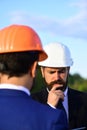 Worker and engineer hold meeting. Architect with puzzled face Royalty Free Stock Photo