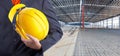 Worker or engineer holding in hands yellow helmet