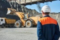 Worker Engineer looks on wheel loader loading truck