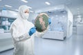 Worker or engineer wears medical protective suit or coverall suit with silicon wafer Royalty Free Stock Photo