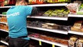 Worker exhibiting seasoning for sale on display rack