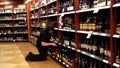 Worker exhibiting wine on the display rack.