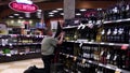 Worker exhibiting wine on the display rack