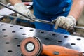 Worker in factory deburring workpieces of metal, close-up