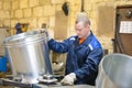 The worker at the factory makes ventilating metal pipes