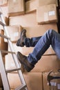 Worker falling off ladder in warehouse Royalty Free Stock Photo