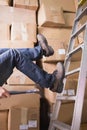 Worker falling off ladder in warehouse Royalty Free Stock Photo