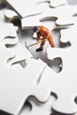 Worker figurine on puzzle pieces Royalty Free Stock Photo