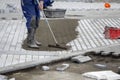 Worker filling the paver joints,