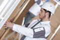 Worker filling walls with insulation in construction site