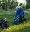 A worker fills water into a bucket,maintaining the greenery image