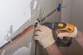 A worker fixes the boxes for sockets to the wall with a screwdriver Royalty Free Stock Photo