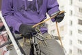 Worker fixes a climbing equipment before descending from the roof. Industrial alpinism.