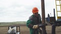 Worker fixes detail on rusty pipe of drilling machine at prospecting site