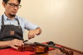 Worker fixing the strings of a violin in a workshop Royalty Free Stock Photo