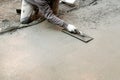 Worker flattening cement mortar on floor