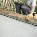 Worker flattening freshly laid concrete Royalty Free Stock Photo