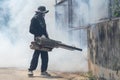 Worker fogging chemical to eliminate mosquito at the street