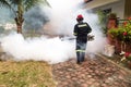 Worker fogging residential area with insecticides to kill aedes