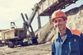 Worker in front of heavy excavator loading gravel into train