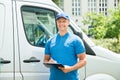 Worker In Front Of Truck Writing On Clipboard Royalty Free Stock Photo