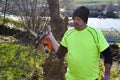 Worker in the garden with a chainsaw.