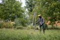 Worker with a gas mower in his hands, mowing grass in front of the house. Trimmer in the hands of a man. Gardener cutting the Royalty Free Stock Photo