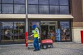 A worker gathers shopping carts with full PPE protection on