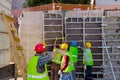 Worker give sign with hand to crane, workers are assembly wooden demountable mold