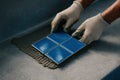 worker with gloves installing blue ceramic tiles on fresh mortar for modern concrete surface renovation, AI Generative Royalty Free Stock Photo