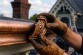 Worker in Gloves Installing a Copper Gutter, generative ai Royalty Free Stock Photo