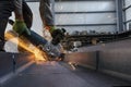 Worker is grinding and cutting to steel material with manual metal cut off wheels in the workshop. Grinding produces sparks. Royalty Free Stock Photo