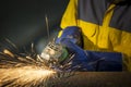 The worker grinding metal in manufacturing plant, sparks flying Royalty Free Stock Photo