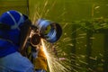 The worker grinding the steel pipe after welding Royalty Free Stock Photo