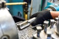 A worker guides a tap on a part on a lathe for internal threading