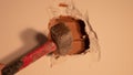 worker with a hammer and chisel makes a hole in the wall at the construction site Royalty Free Stock Photo