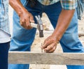 Worker hammering nail into wood Royalty Free Stock Photo