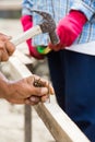 Worker hammering nail into wood Royalty Free Stock Photo