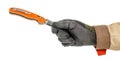 Worker hand in black protective glove and brown uniform holding by fingers blade of open pocket knife with bright orange handle Royalty Free Stock Photo