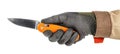 Worker hand in black protective glove and brown uniform holding open pocket folding knife with bright orange handle isolated on Royalty Free Stock Photo