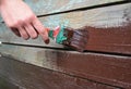 Worker hand with brush painting and repair wooden wall. Paint Old Wooden Surface. Royalty Free Stock Photo