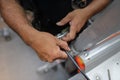 Worker hand clipping locking Karabiner into first man up line permanently attached into roof safety anchor point