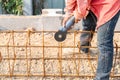 Worker hand cuts off pieces of reinforcement using an angle grinder Royalty Free Stock Photo