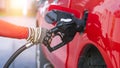 Worker hand holding nozzle for filling diesel fuel into red pick up car at refuel station Royalty Free Stock Photo