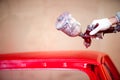 Worker hand painting a hood of car in auto workshop Royalty Free Stock Photo