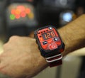 Worker hand with remote control designed like wrist watch, blurred DC inverter MMA welder on the background