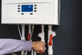 Worker hand remote or installing double-circuit gas boiler for winter home heating and water heating. Energy saving and Royalty Free Stock Photo
