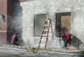 Worker hand scraping old paint on concrete wall. Old paint remover. Preparation for painting a wall